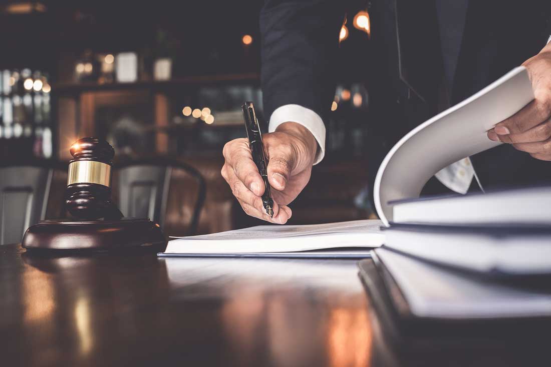 Lawyer writing notes while reviewing a client's legal case